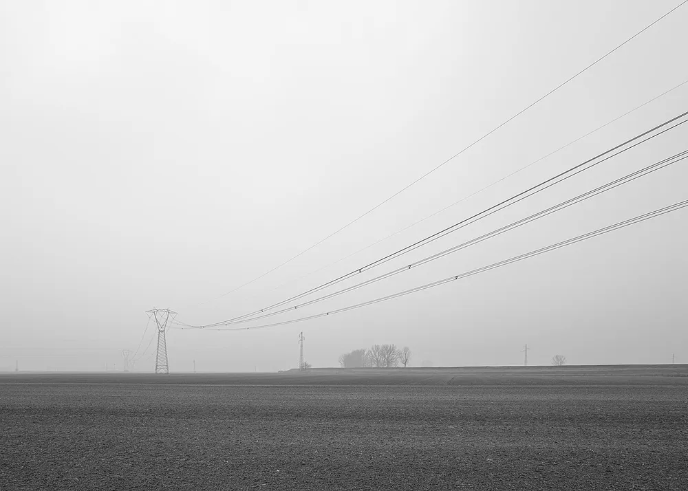 High-voltage power lines cross a field near Crevalcore, Italy.