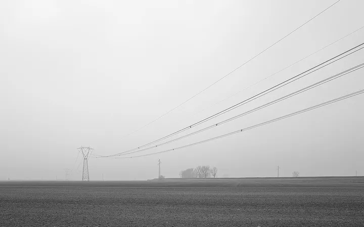 High-voltage power lines cross a field near Crevalcore, Italy.