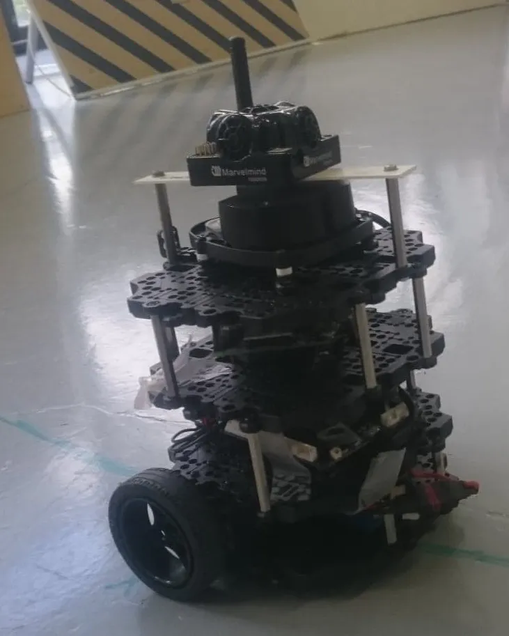 A wheeled TurtleBot3 mobile robot with stacked electronics on a laboratory floor.